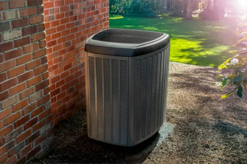 Outdoor air conditioning unit beside a brick home